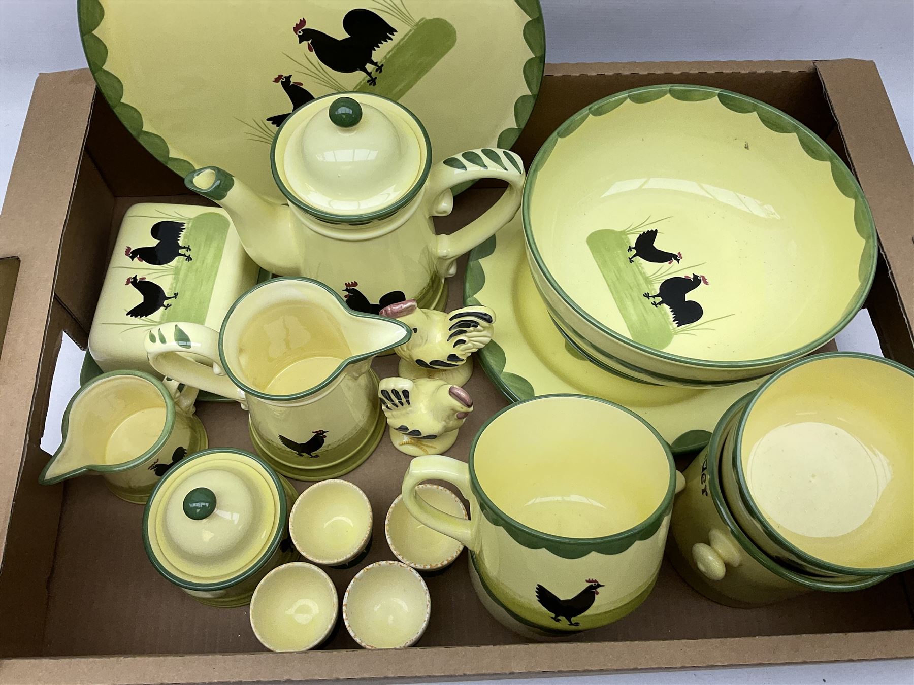Zeller Fayencerie dinner and tea wares, decorated in cockerels against a yellow ground, with green scalloped border, comprising cake stand, two plates, bowl, three large teacups and saucers, coffee pot, milk jug, cream jug, lidded sugar bowl, pair of cruets modelled as cockerels, butter dish and cover, and utensils pot, and four similar egg cups, in one box 