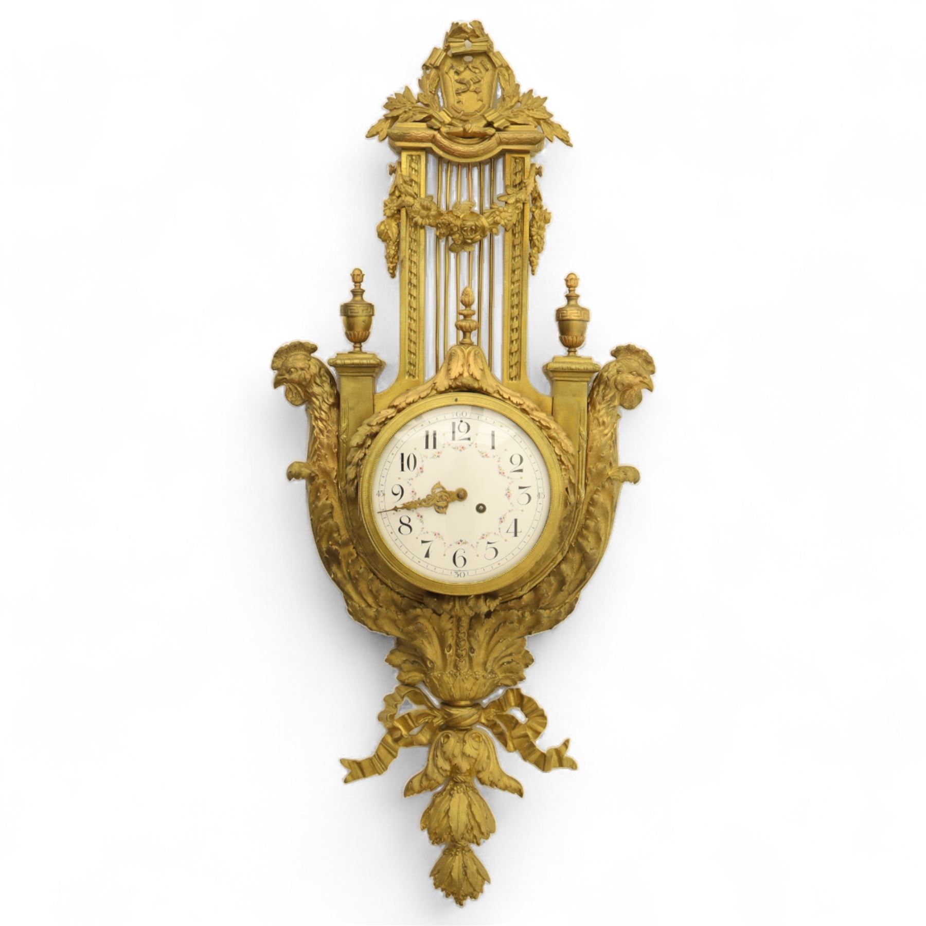 French- late 19th century cast brass and ormolu 8-day cartel wall clock, with a profusely decorated case comprising urn finials garland wreaths, ribbon bows and French cockerels, white enamel dial with minute track, Arabic numerals, garland swags and pierced gilt hands, twin train movement with a recoil anchor escapement and countwheel strike, striking the hours and half-hours on a bell. With pendulum and key.