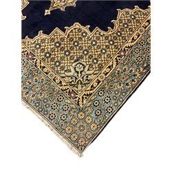 Central Persian Qum indigo ground rug with silk inlay, the plain field decorated with floral design medallion and lattice spandrels, the wide border decorated with trailing flowers and foliage 