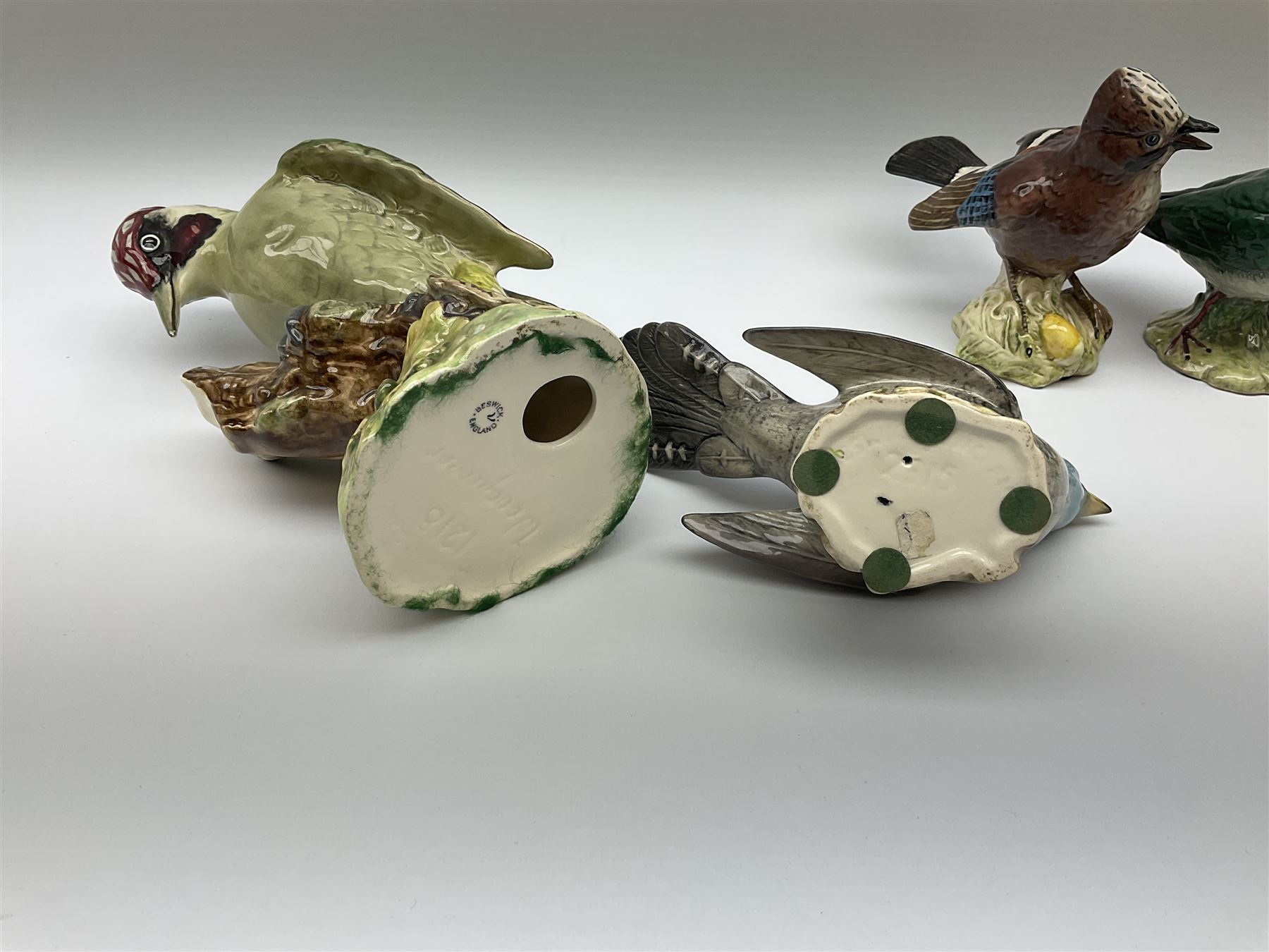 Collection of Beswick birds, comprising woodpecker model no 1218, jay model no 2417, cuckoo model no 2315, lapwing model no 2416, lesser spotted woodpecker model no 2420, and kookaburra 1159. 