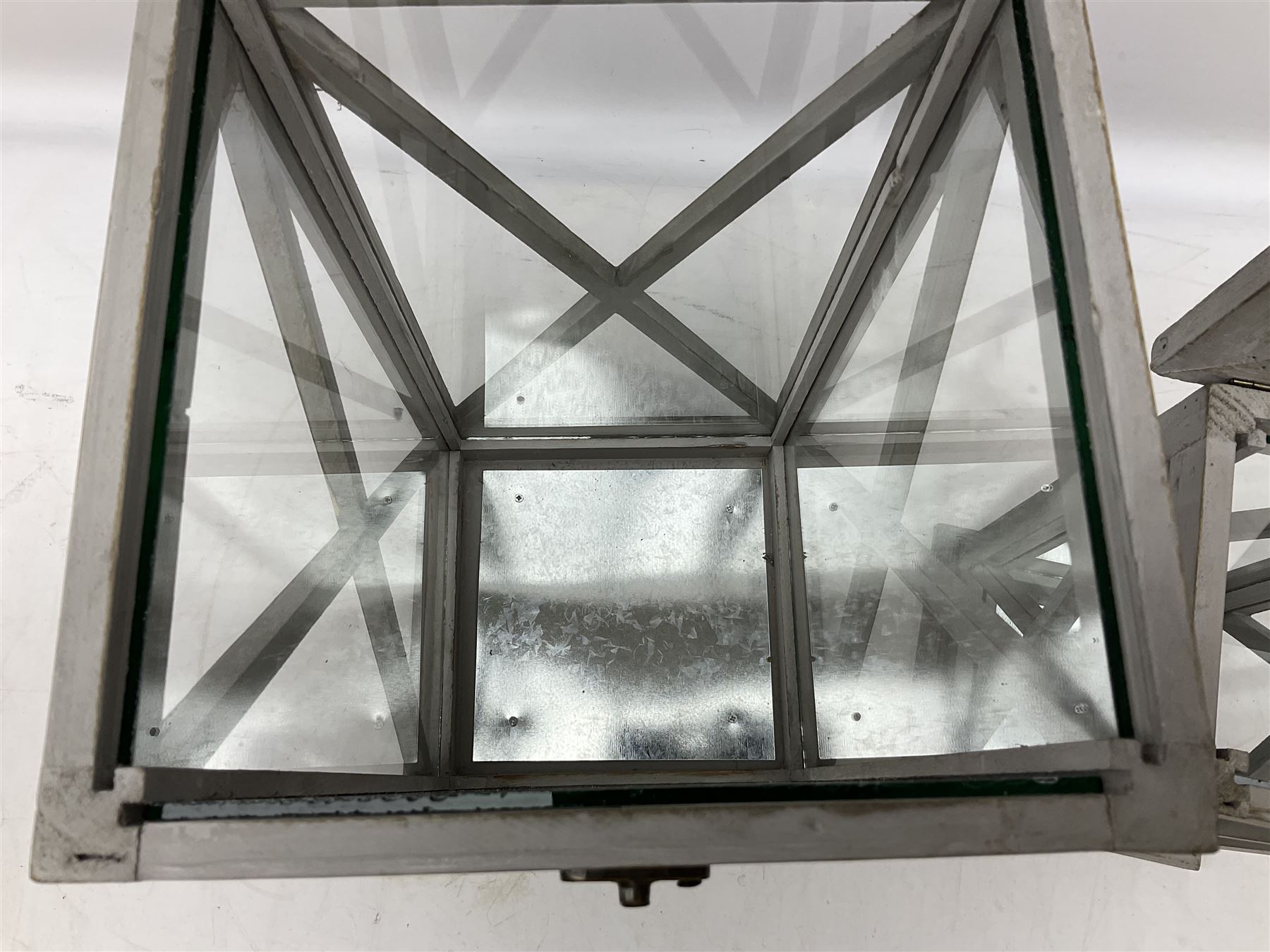 Two wooden lanterns with four glass sides, loop handles and open tops, largest example 58cm