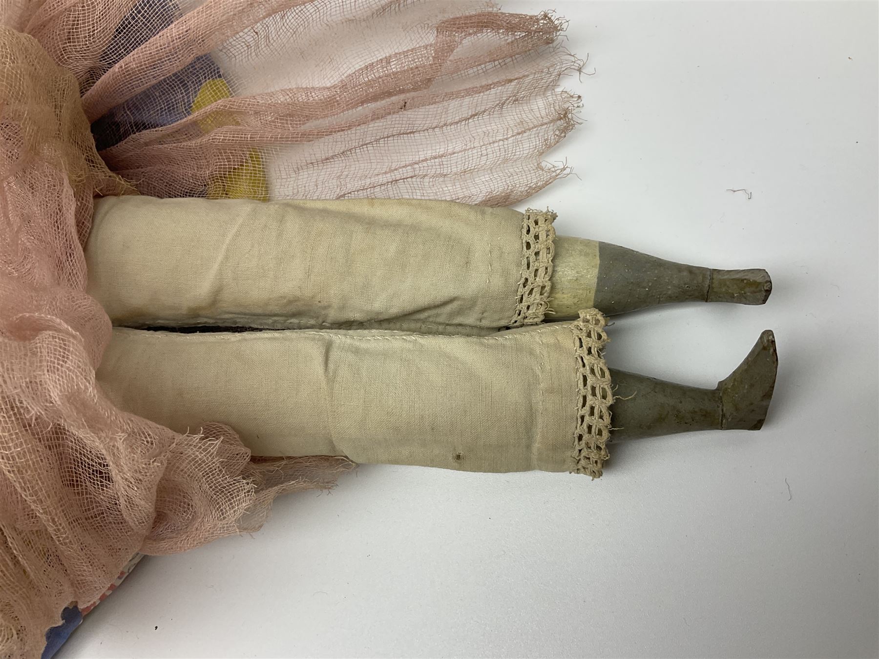 Victorian large wax over composition Pumpkin head doll, with inset dark glass eyes, moulded blonde hair in curls, stuffed body with carved and painted wooden limbs, grey painted boots, floral satin dress with netting underclothes H61cm