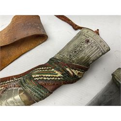 Saudi Arabian khanjar dagger with 29.5cm curving double edged  steel blade; white metal and copper mounted horn grip; in white metal mounted brass and leather scabbard incorporating embroidered leather wearing strap