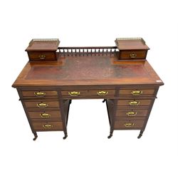 Maple & Co - Edwardian mahogany twin pedestal desk, the raised back with spindle gallery and open shelf to centre flanked by two trinket drawers, rectangular top with inset writing surface, fitted with one long and eight short graduating drawers flanked by fluted uprights, raised on brass and ceramic castors, stamped to central drawer