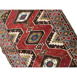 Anatolian Turkish red ground rug, decorated with three central lozenges, the multi-colour guarded border with repeating geometric shapes