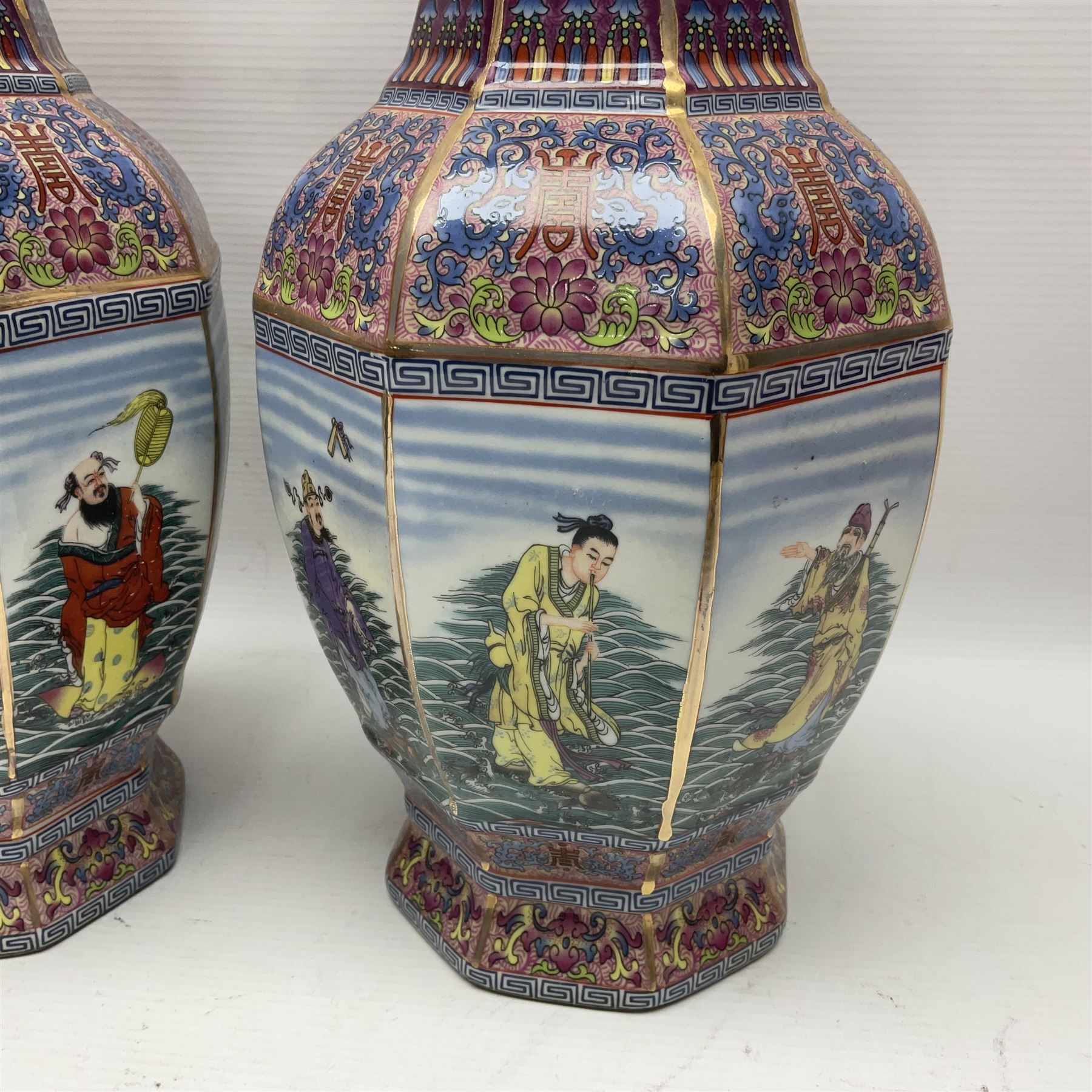 Pair of 20th century Chinese vases, of octagonal baluster form, each central panel decorated with one of The Eight Immortals, bordered by panels of floral motifs upon a pink/purple ground, H33.5cm