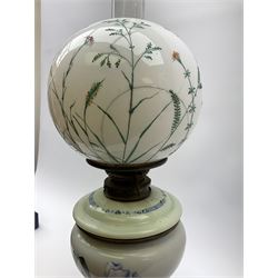 A Victorian oil lamp, with opaque glass reservoir hand painted with flowers beneath a Hinks burner and supporting a globular floral painted opaque glass shade and glass chimney, H47.5cm. 