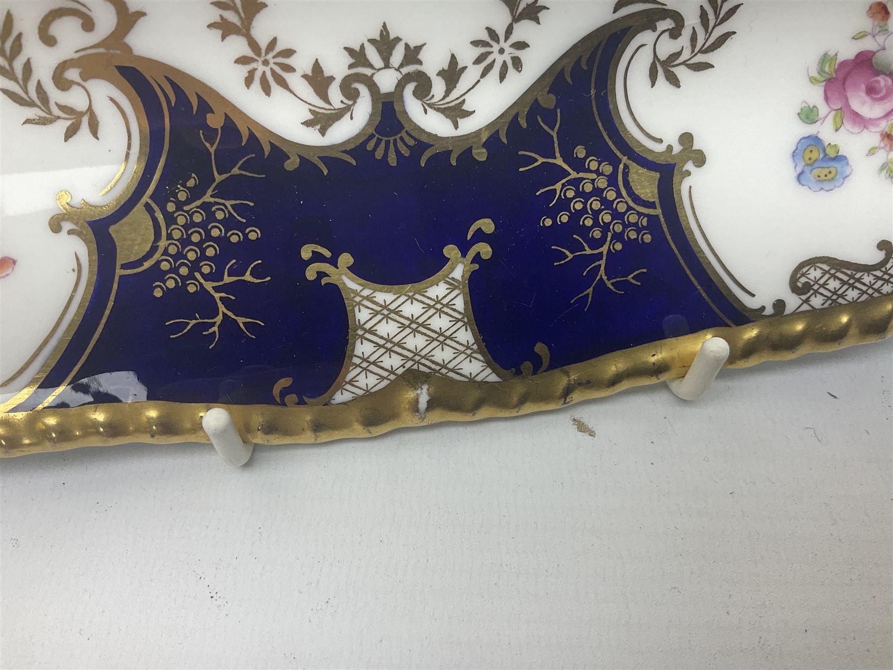 Coalport cobalt blue batwing pattern tea wares, decorated with finely enamelled floral sprays within gilt reserves, comprising teacup trio, coffee can and saucer and other cup and saucer, twin handled cake plate, milk jug and open sucrier, and circular plate retailed by T. Goode & Co London, pattern no Y2665,  all with green Coalport AD 1750 marks beneath, largest W26cm (11)