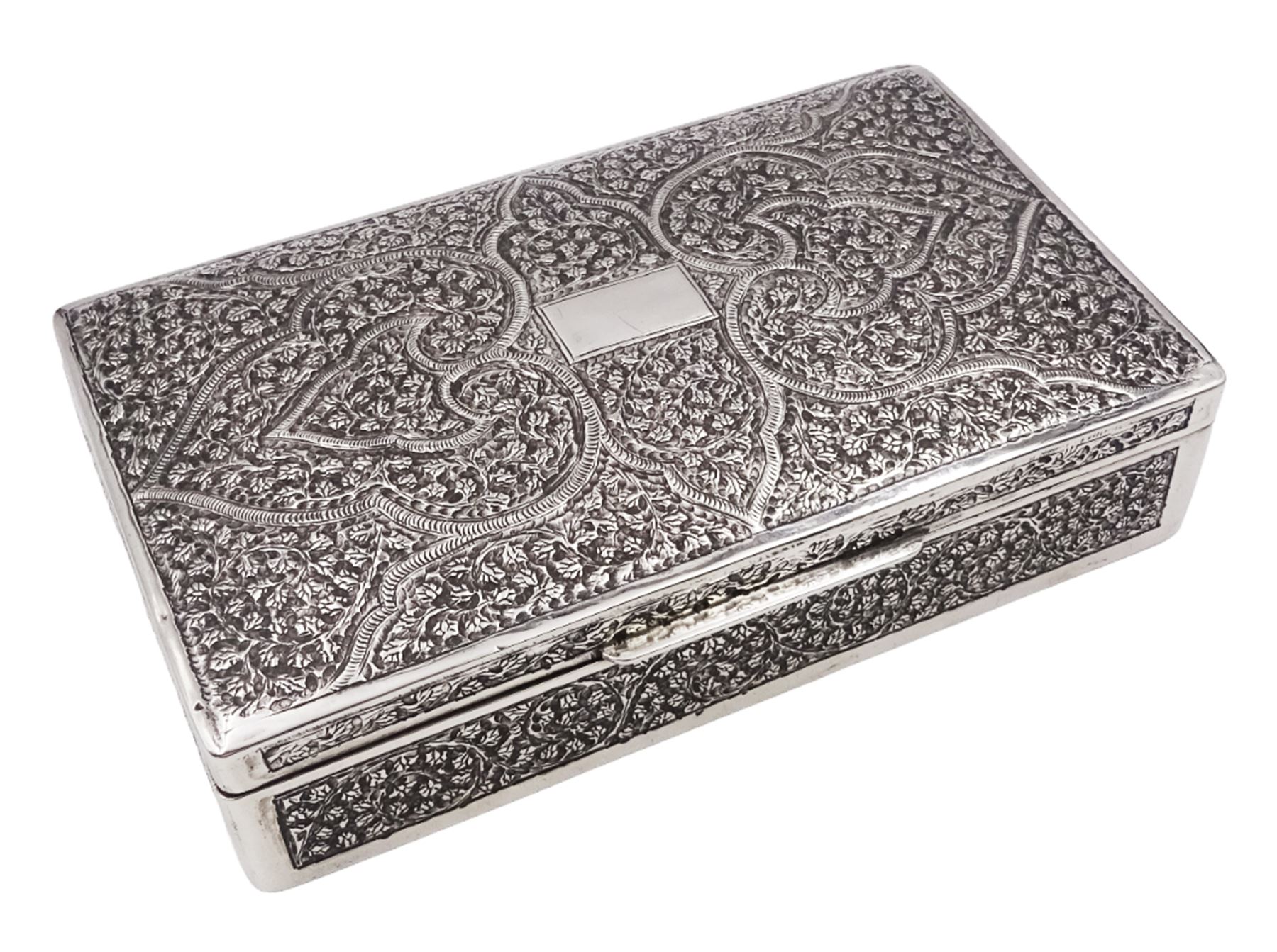 Indian silver cigarette box, of rectangular form with chassed and embossed foliate decoration and vacant rectangular panel to hinged cover, opening to reveal softwood lined interior with division, H3.3cm W14.3cm D8.5cm, stamped Silver VR Co with elephant mark