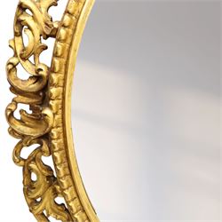Late 19th century giltwood oval wall mirror, the bevelled plate within a gadroon moulded inner slip, surrounded by pierced scrolling foliate and acanthus carved frame, richly gilded with worn patina indicative of age and use