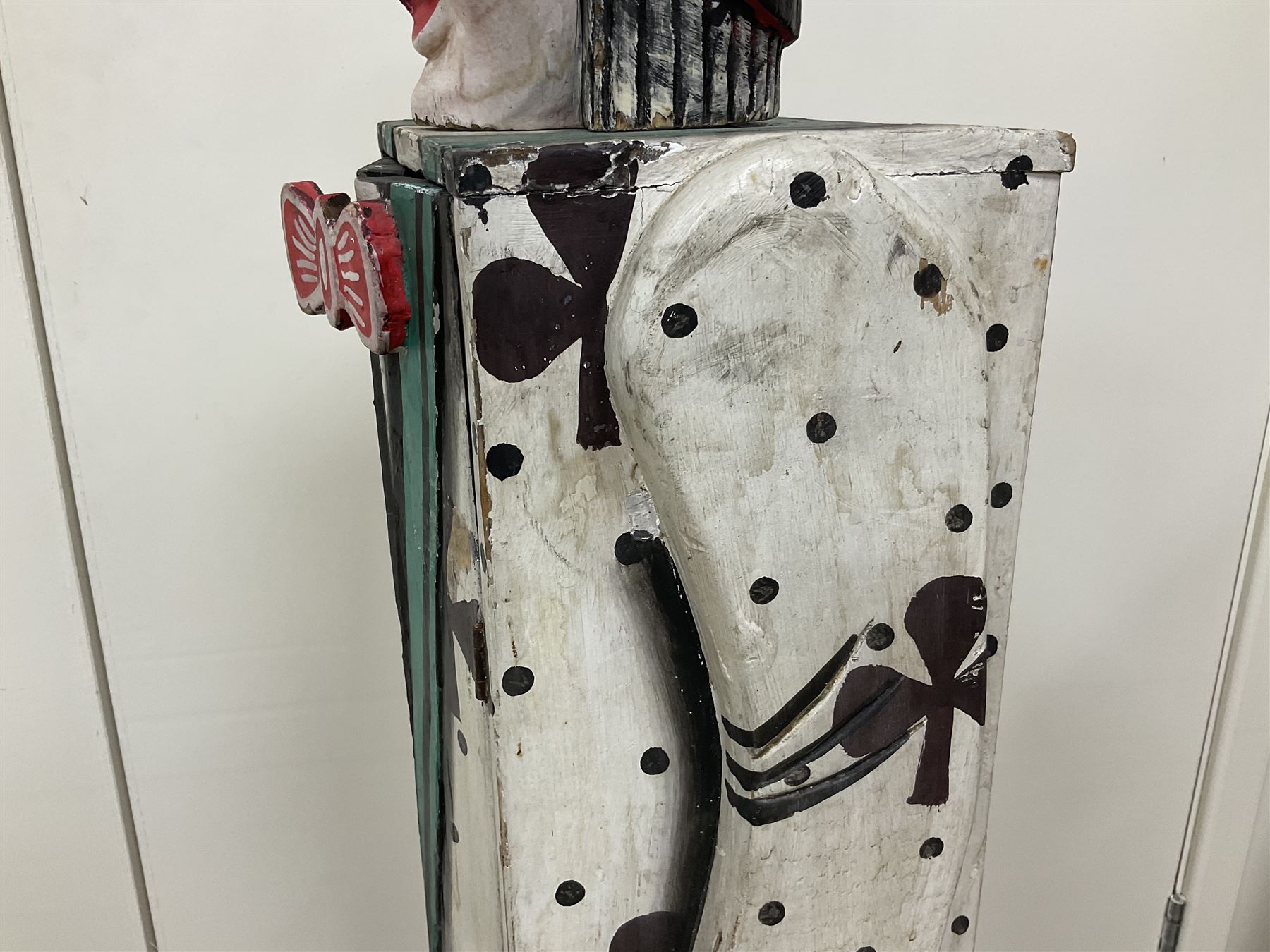 Folk art circus clown cabinet, the the two hinged doors with bow tie decoration opening to reveal fitted shelved interior, the body painted with polka dots and spades, H121cm