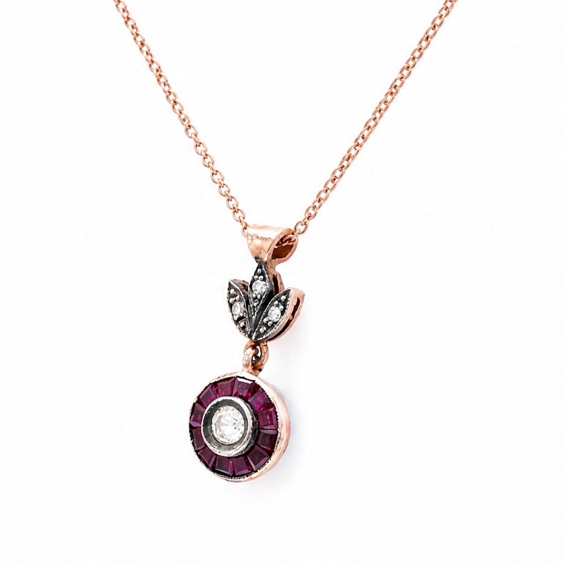 Gold and silver ruby and diamond pendant, single round brilliant cut diamond, surrounded by calibre cut rubies and round brilliant cut diamonds, suspending from a fancy pendant set with further diamonds, on a rose gold plated silver chain necklace, total diamond weight approx 0.30 carat, total ruby weight approx 0.30 carat