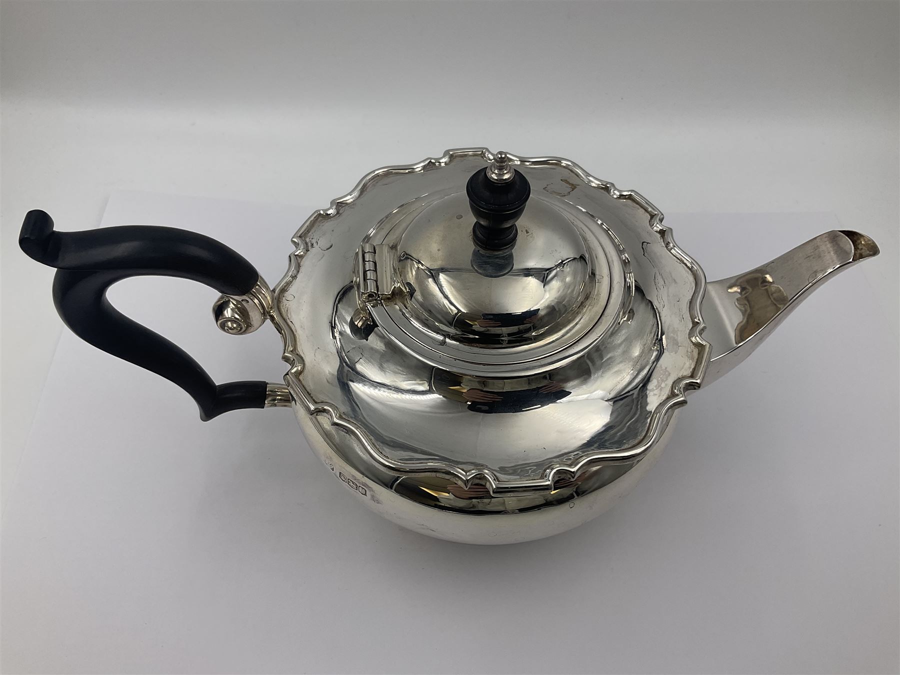 1920s five-piece silver tea service, comprising teapot, coffee pot, hot water pot, twin handled open sucrier and milk jug, each of squat circular form with shaped rim, the teapot, coffee pot and hot water pot each with ebonised handle and finial, the sucrier and milk jug with acanthus capped scroll handles, all upon circular foot, hallmarked R F Mosley & Co, Sheffield 1926 & 1927, tallest H24cm
