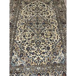 Persian Kashan ivory ground carpet, the field decorated profusely with interlacing branch and stylised plant motifs, scrolling border with overall floral design 