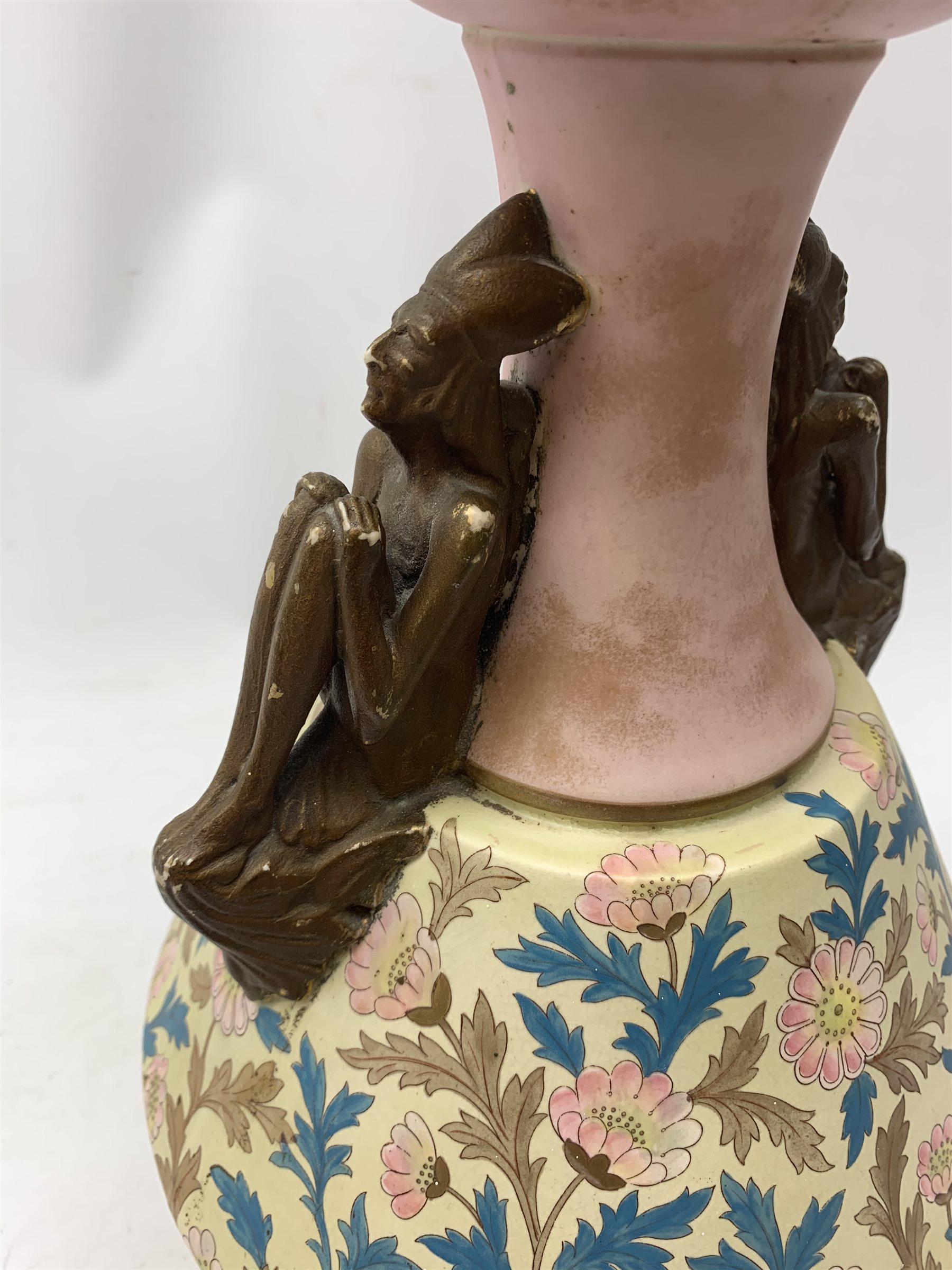 A late 19th century Aesthetic Movement Old Hall vase designed by Christopher Dresser, the flared body decorated with stylised flowering vines, leading to a tapering neck and flared rim with twin figural handles (one s/d), and raised upon a circular footed base, with printed mark beneath, H35cm. 