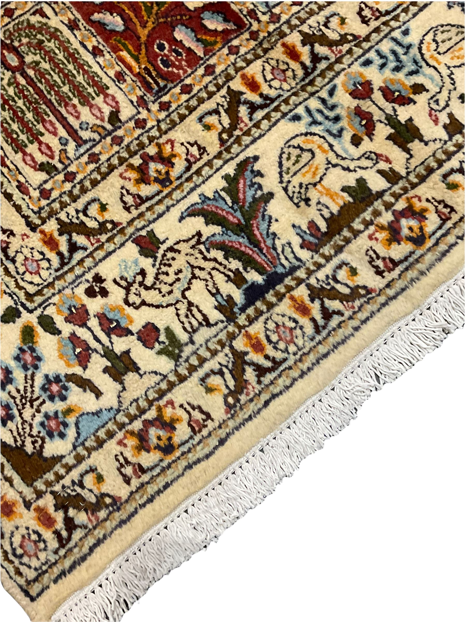 Persian Heriz design rug, ivory ground with rectangular panels each depicting garden scenes of tree of life, plants and Boteh motifs, the guarded border decorated with wildlife and bird scenes