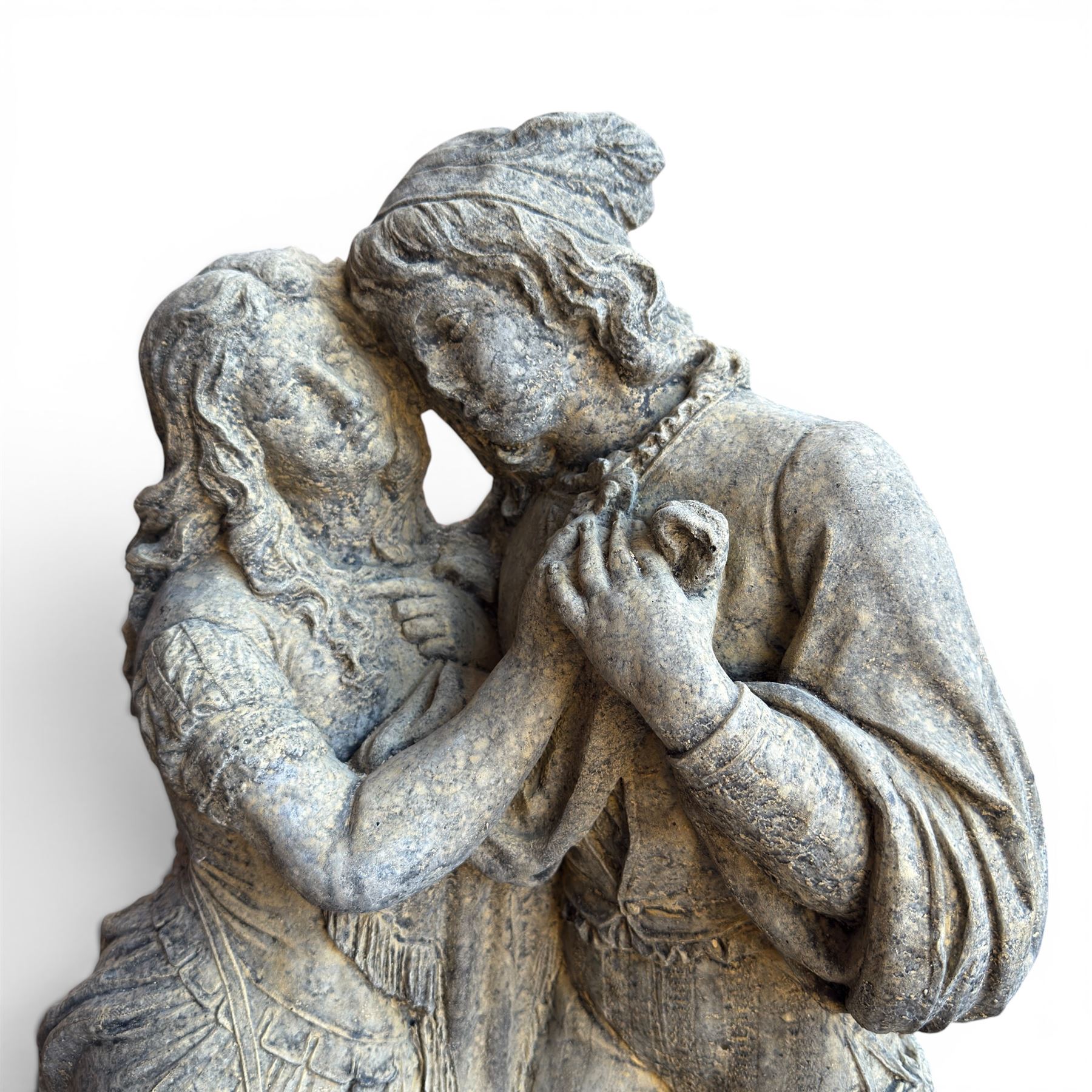 Composite garden statue group of Romeo and Juliet embracing, the couple adorned in Medieval dress standing on a naturalistic base with fallen flowers, raised on a Neoclassical fluted pedestal with Anthemion leaf motifs