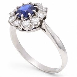 Platinum sapphire and diamond cluster ring, single round cut sapphire of approx 0.85 carat, surrounded by ten round cut diamonds, total diamond weight approx 0.40 carat