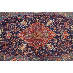 North West Persian Sarouk hand-knotted rug, indigo field with central stepped medallion with pendants, issuing an all-over arrangement of scrolling vinery, palmettes and stylized floral sprays, enclosed by a broad turquoise field of sinuous arabesques,, ivory spandrels with foliate decoration, madder red main border of stylized palmettes, and flowering vines, flanked by reciprocal guard stripes, cotton fringe ends 
