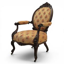 Victorian mahogany open armchair, oval stuff-over back with floral upholstery, moulded and foliate carved frame with pierced crest, padded open arms with scroll terminals, serpentine seat rail on cabriole supports