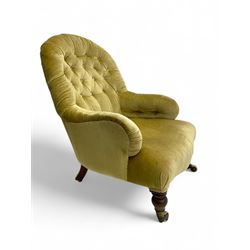 Late 19th century button-back nursing chair, upholstered in olive-green velvet, shaped back with padded arms, raised on turned front supports terminating in castors