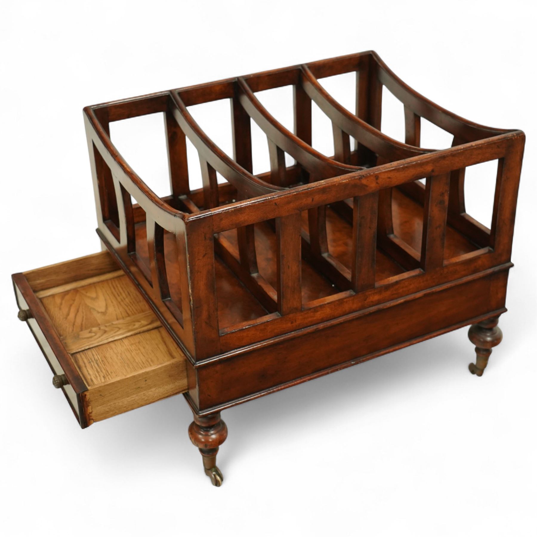 Late 20th century large mahogany canterbury, of rectangular form with four divided curved upper racks, single frieze drawer with brass knob handles, raised on turned legs with brass castors