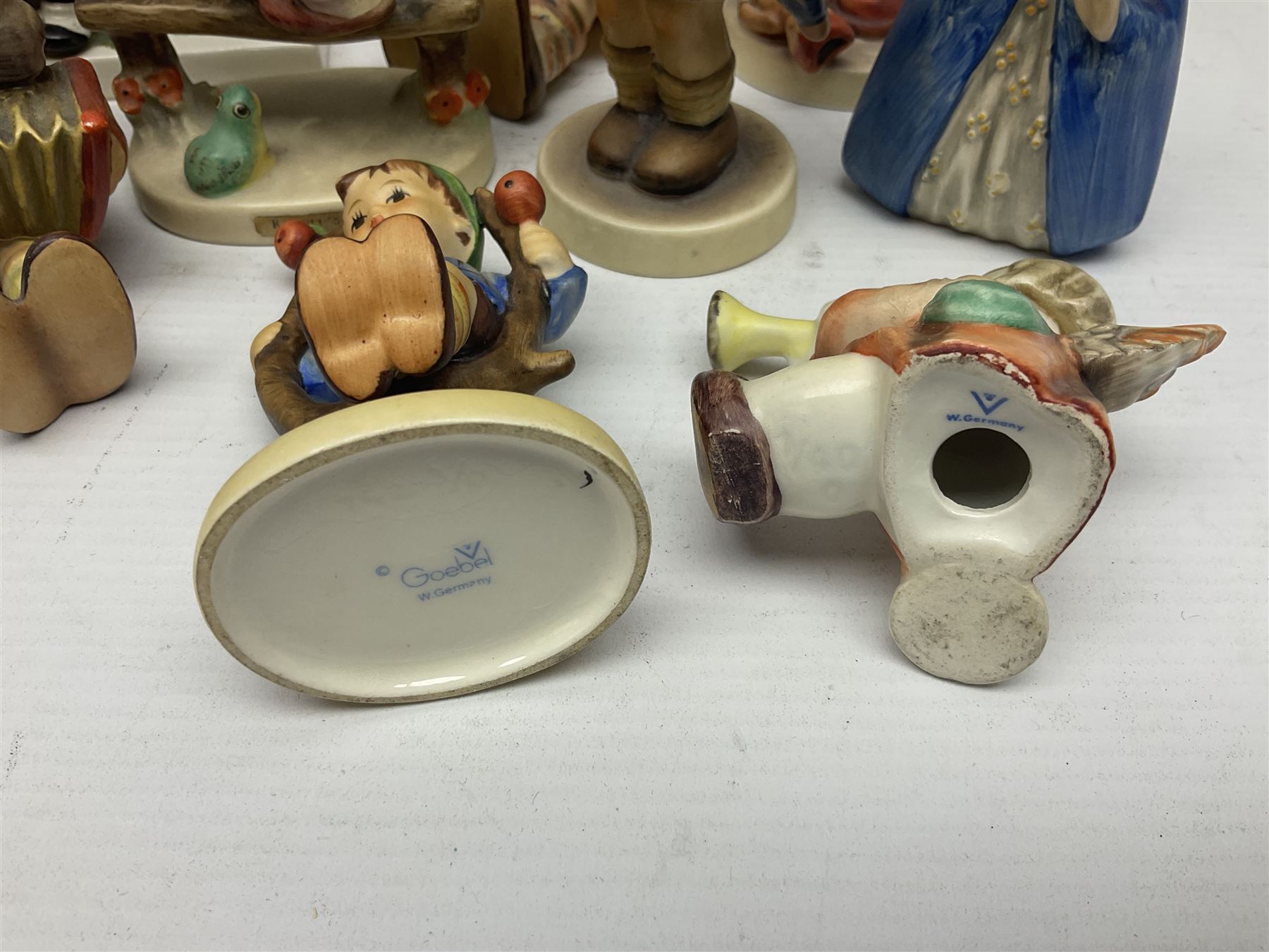 Sixteen Goebel Hummel figures, including Charlot A Young Man's Fancy, Stormy Weather and Bookworm, all with impressed and printed marks beneath