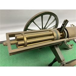 Scratch built brass model of an 1861 Gatling Gun with rotating barrels, hinged cover revealing mechanism, on metal bound wooden spoked wheels and rectangular base L47cm H22cm