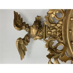 Large Regency carved wood and gesso circular convex mirror, eagle pediment on platform flanked by acanthus leaf scrolls, moulded surround and ebonised slip
