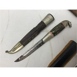 Eastern dagger with 14.5cm ornate fullered blade and nickel mounted horn grip; in nickel mounted ebonised wooden scabbard L25,5cm overall; another smaller Eastern dagger with animal head pommel and nickel mounted leather scabbard; three small sheathe knives with simulated antler grips; letter opener in the form of a German hunting knife with hoof grip; and Japanese wooden Floating Fish Knife with stainless steel blade (7)